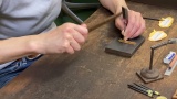 加賀象嵌体験は始めに前もって彫っている溝に銀線を嵌め込みます。どうして外れないのかな？そんなお話もしながら進行します。