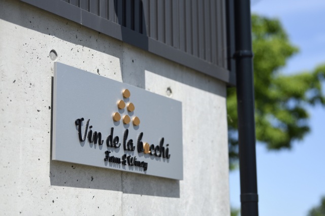 ワイナリーの壁にかかるVin de la bocchiの看板
